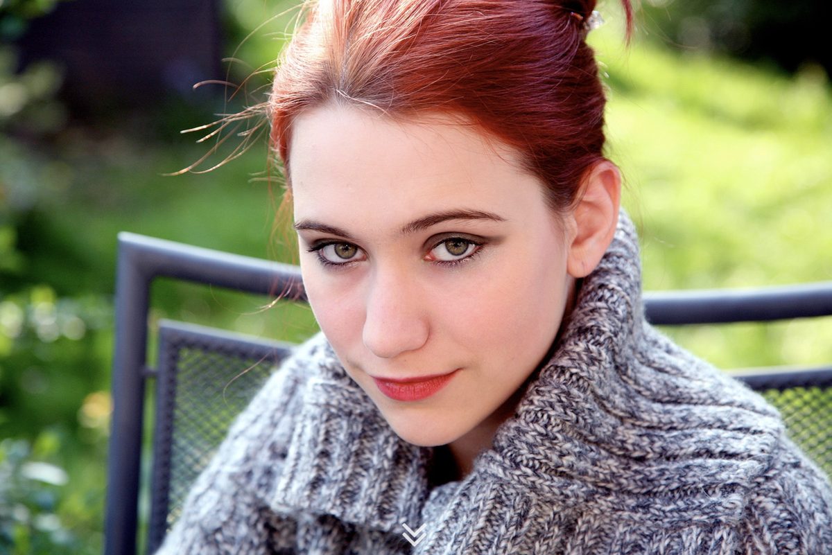 Woman with red hair in a knitted scarf