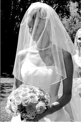 Bride in veil holding a bouquet, black and white