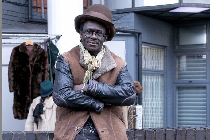 Man in a hat and coat on a city street